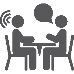 Zwei Personen sitzen am Tisch und führen ein Gespräch für Beratung oder Meeting.